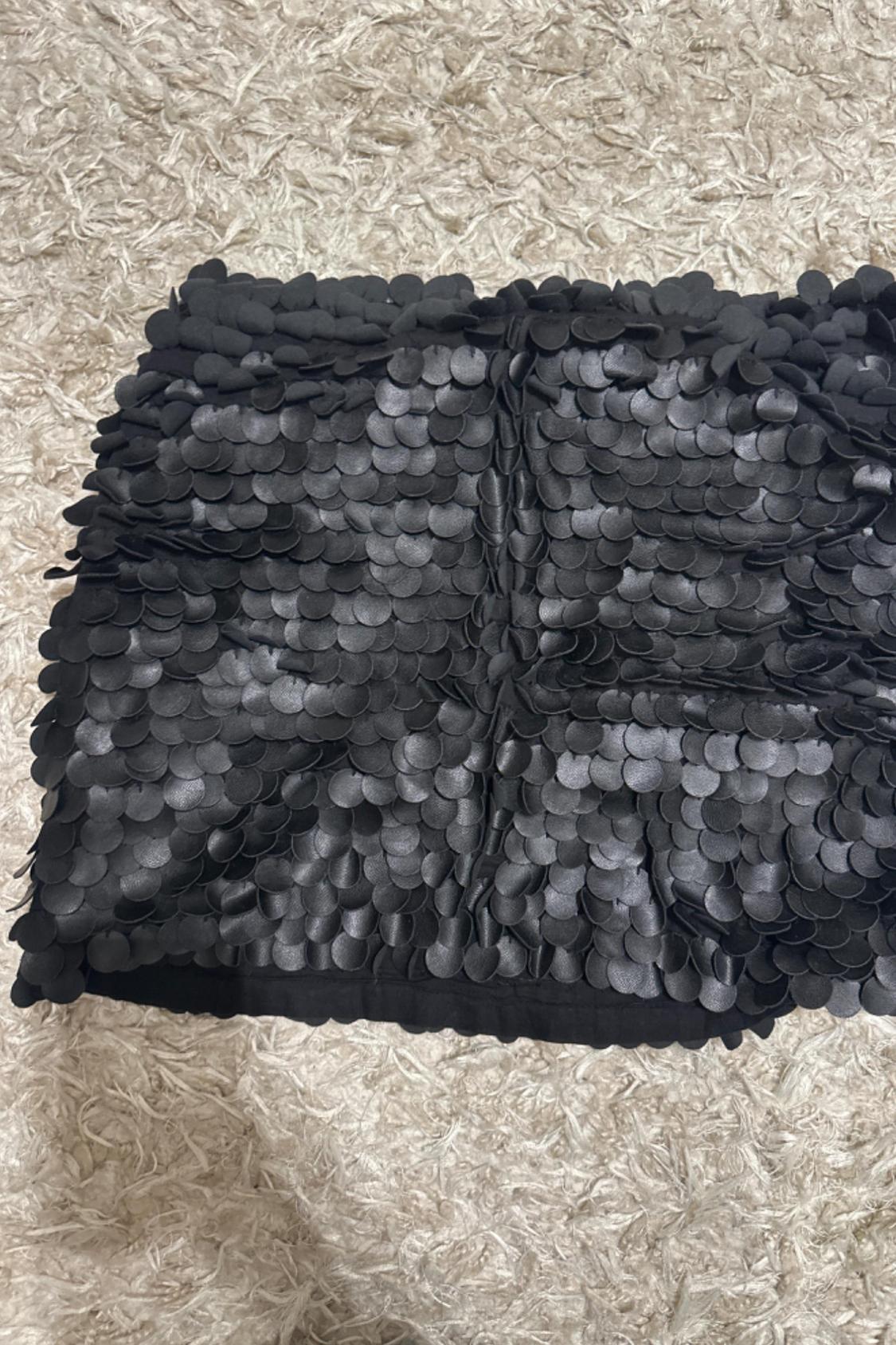 Close-up of black skirt with large sequins.