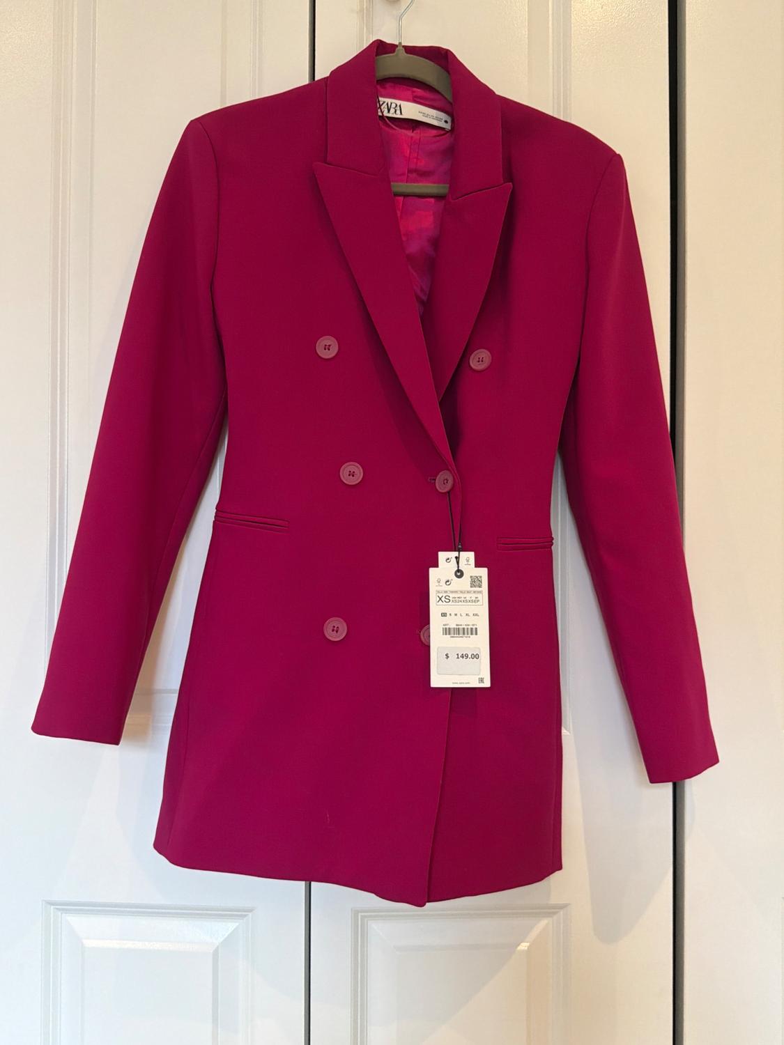 Fuchsia double-breasted blazer with matching buttons, hanging on a white door. Visible tags with the text ZARA, XS, and $149.00.