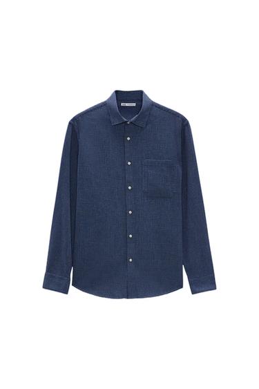 Blue, long-sleeved shirt with a small check pattern, chest pocket and front buttons. White background.