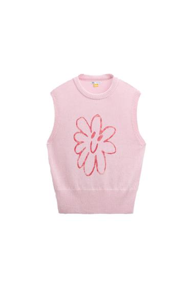 Front view of a pink waistcoat with a smiling flower print in the centre.