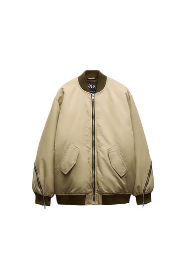 Front view of a beige bomber jacket with front flap pockets and a zip fastening.