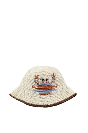 Front view of a blue and white braided bucket hat with crab embroidery on the front and contrasting trim.