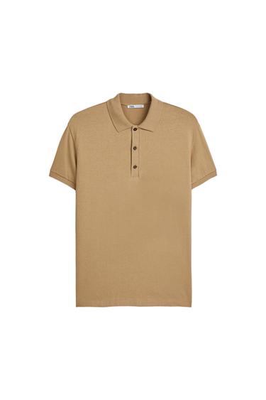 Beige polo shirt with a classic collar and three front buttons. Visible inner label with "ZARA" text. White background.
