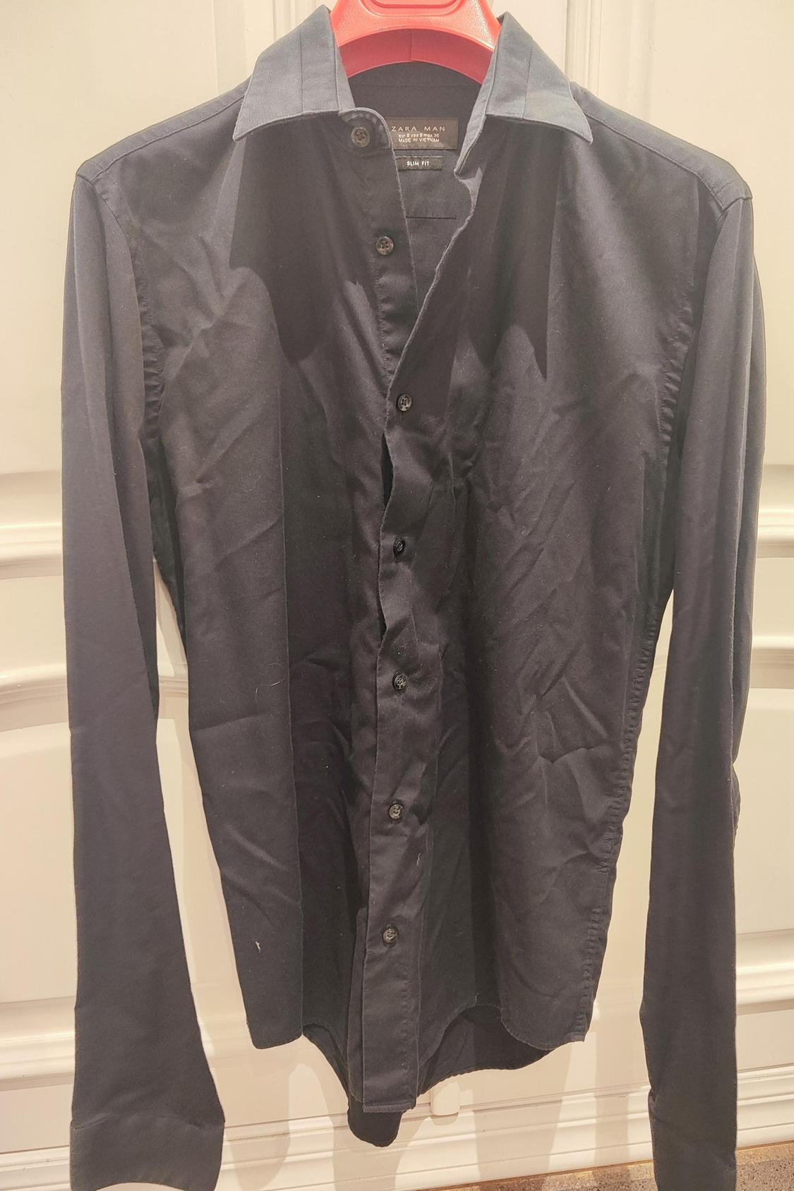 Front view of black long-sleeved shirt with buttons and classic collar.