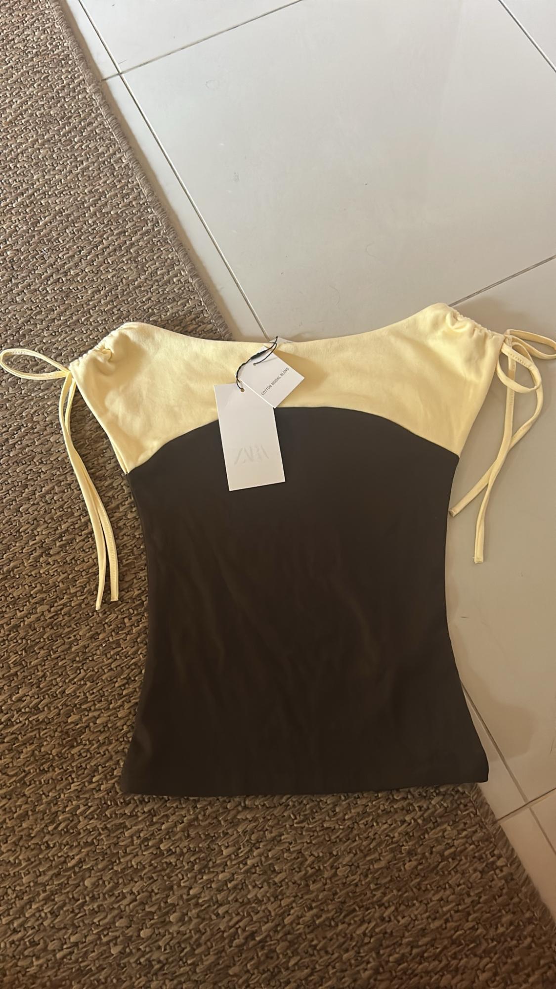 Yellow and dark brown top with side ties on a tiled floor and carpet. Labels: ZARA and COTTON MODAL BLEND.