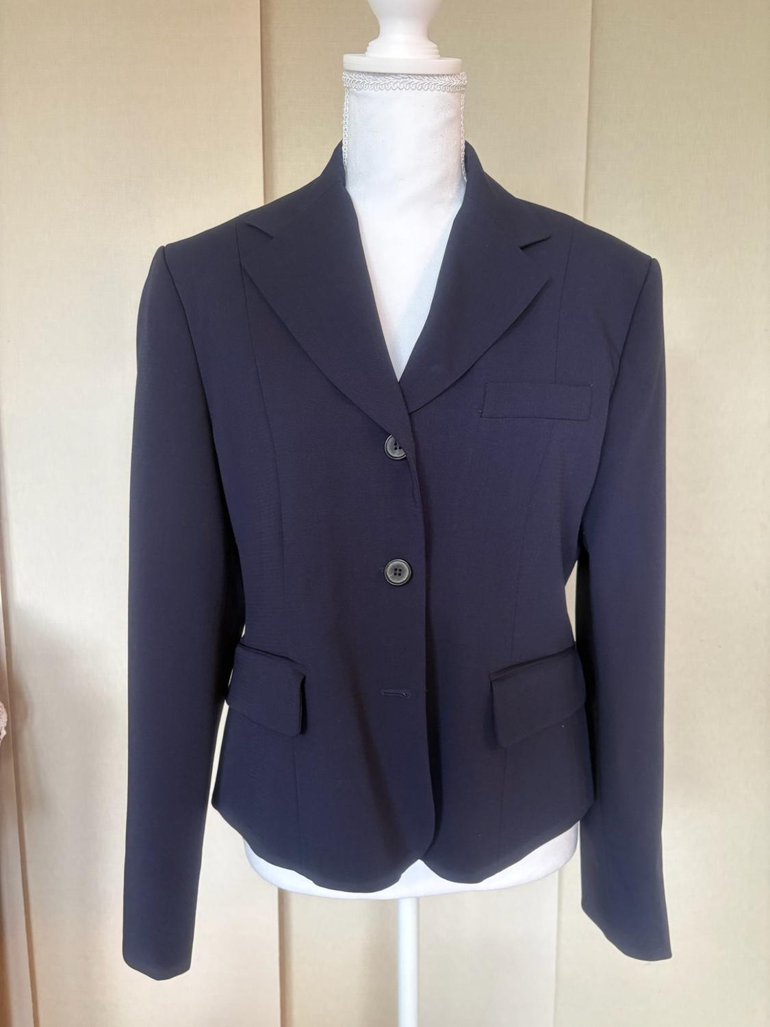 Classic-cut navy blue blazer with buttons and flap pockets, displayed on a white mannequin against a neutral background.