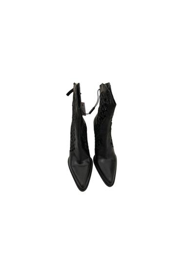 Black pointed-toe boots with lace detailing on the sides, viewed from above on a white background.