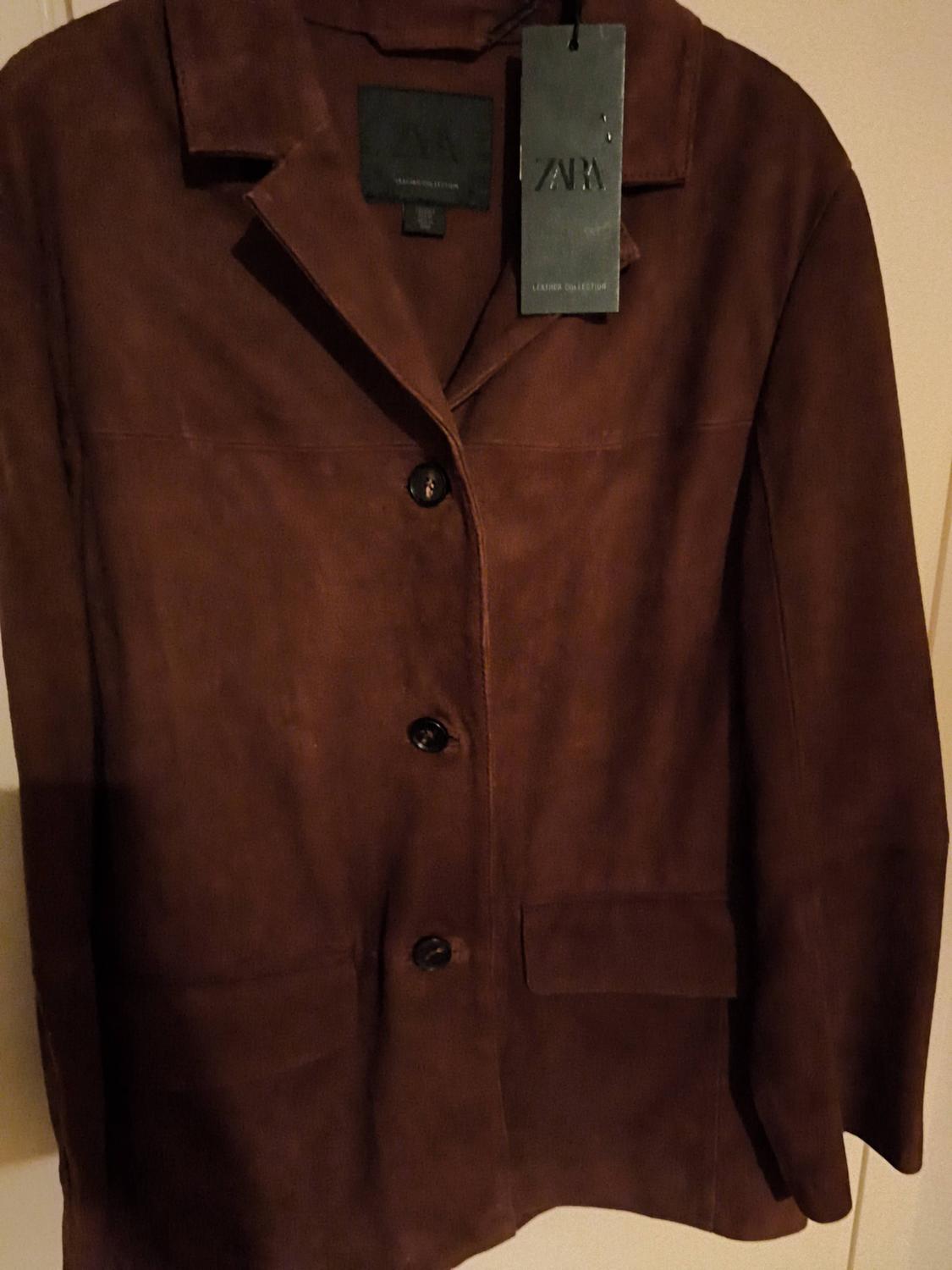 Brown suede jacket with four buttons and Zara label. Warm and elegant vibe.