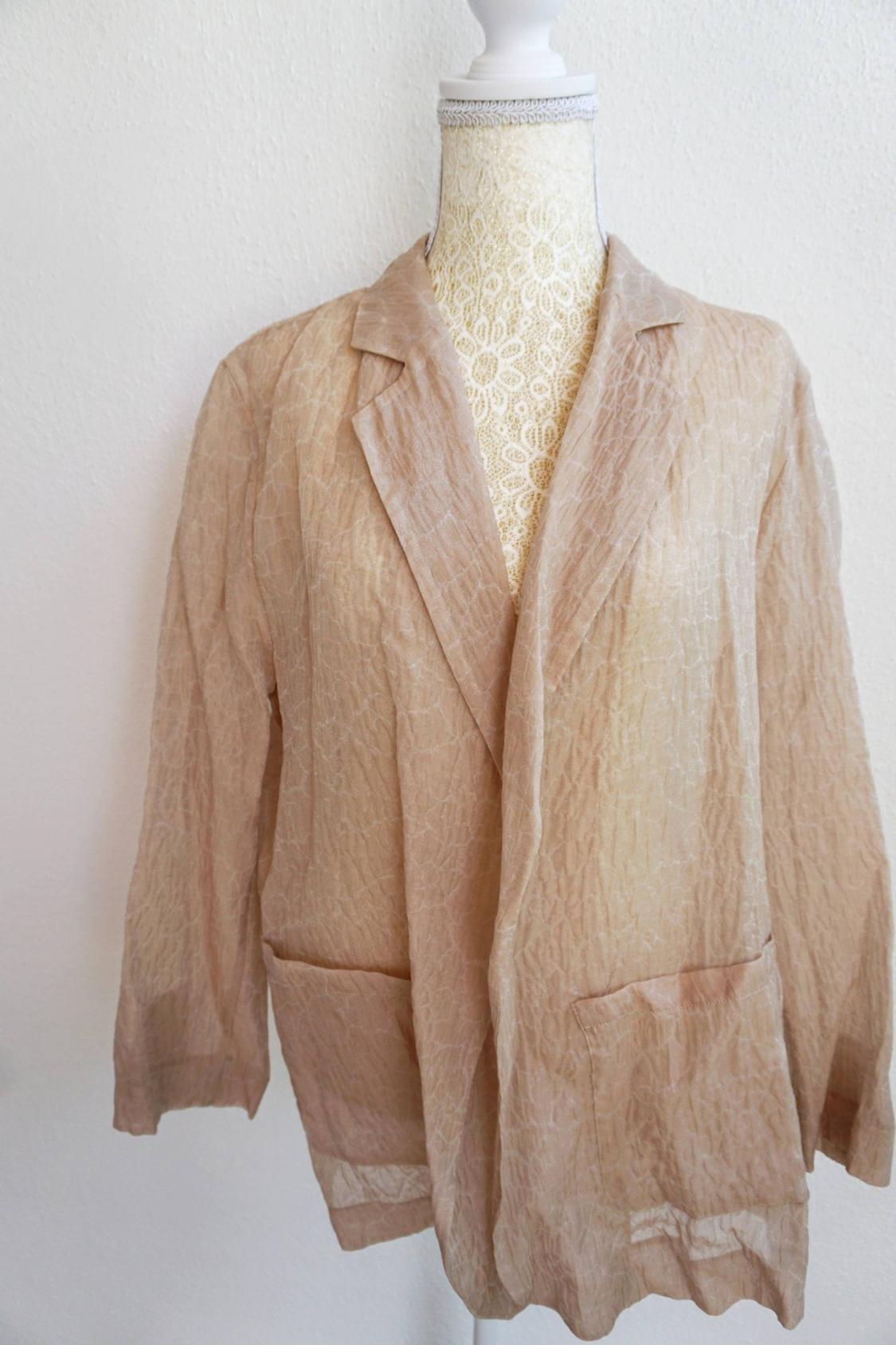 Beige crinkled texture jacket on a white mannequin with lace. The jacket has lapels and front pockets.