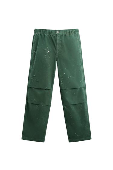 Front view of green pants with white spots and side pockets.