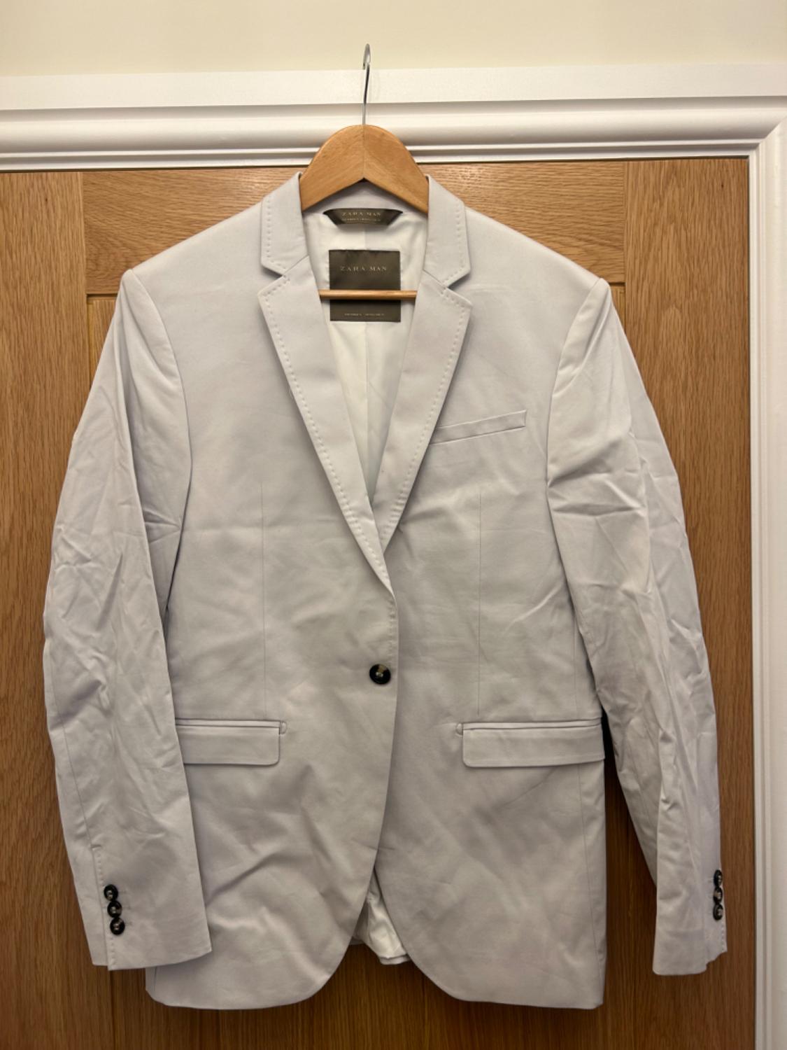 Front view of a white bag with notched flaps and front flap pockets.