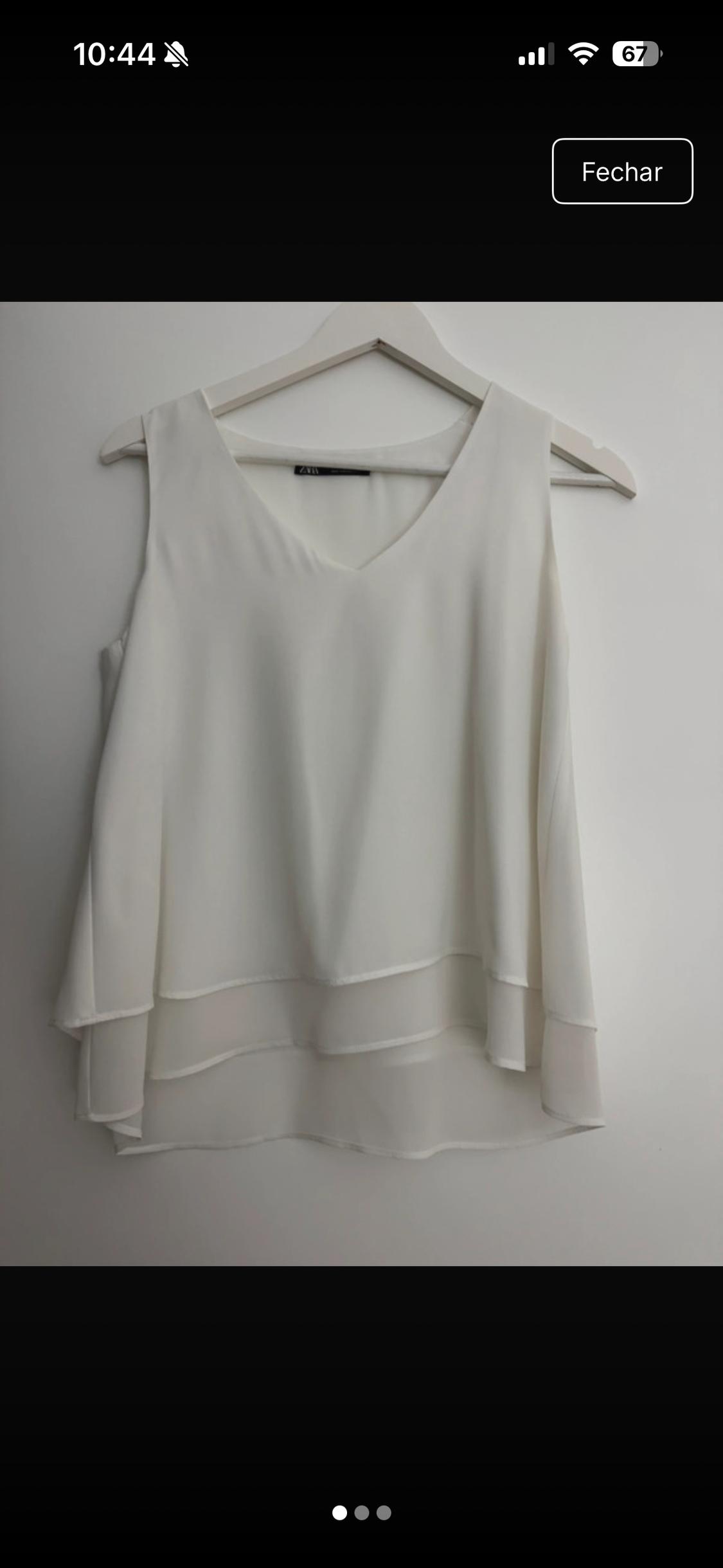 White sleeveless blouse, V-neck and layered hem on a hanger on a white background. Text: 10:44, 67, Close, ZARA.