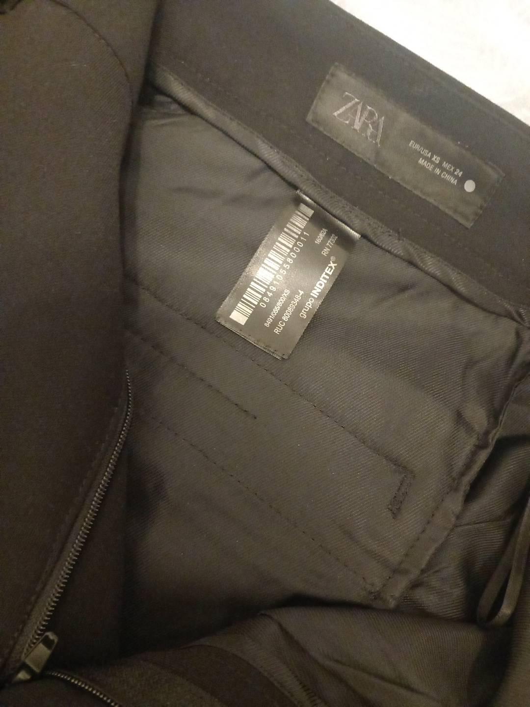 Labels on black garment: ZARA EUR/USA XS MEX 24 MADE IN CHINA 08491055800011 16362A RN 77302 8491/055/800/XS RUC 80089348-4 INDITEX group