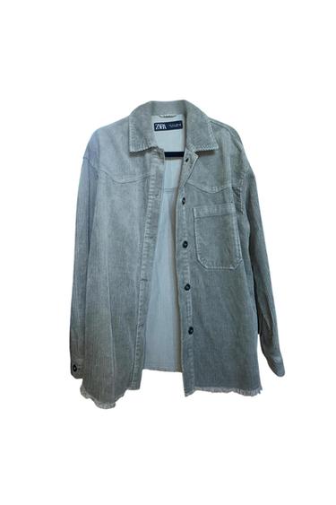 Front view of a gray shirt with a visible lapel, pockets, and black buttons.