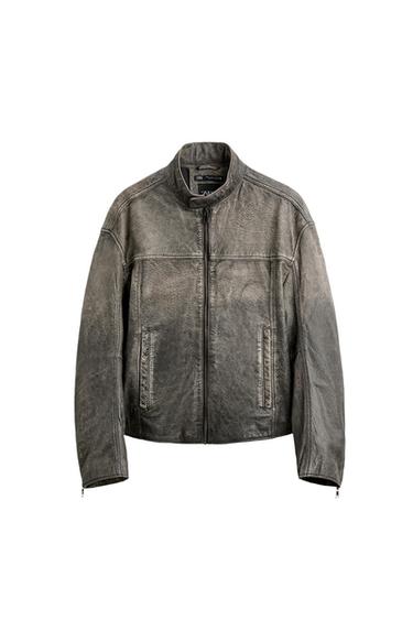 Worn grey jacket with a front zip fastening, stand-up collar and side pockets against a white background.