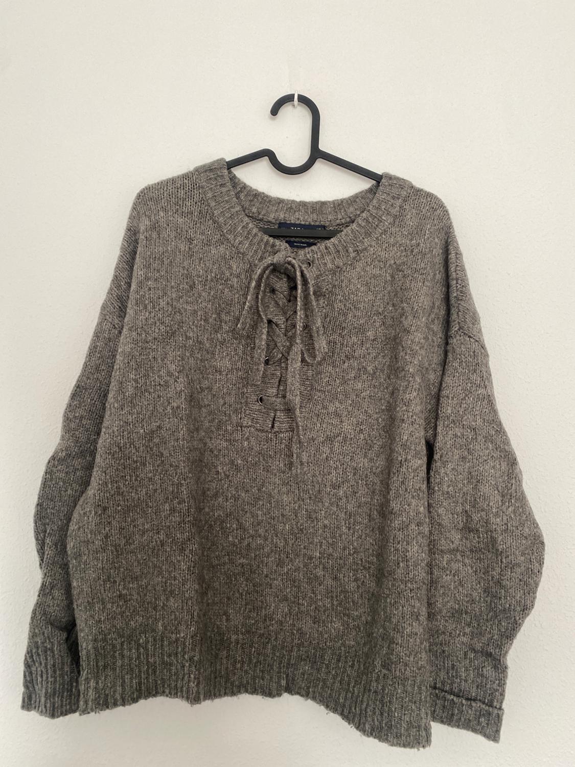 Front view of a grey crew neck jumper with chest drawstrings.