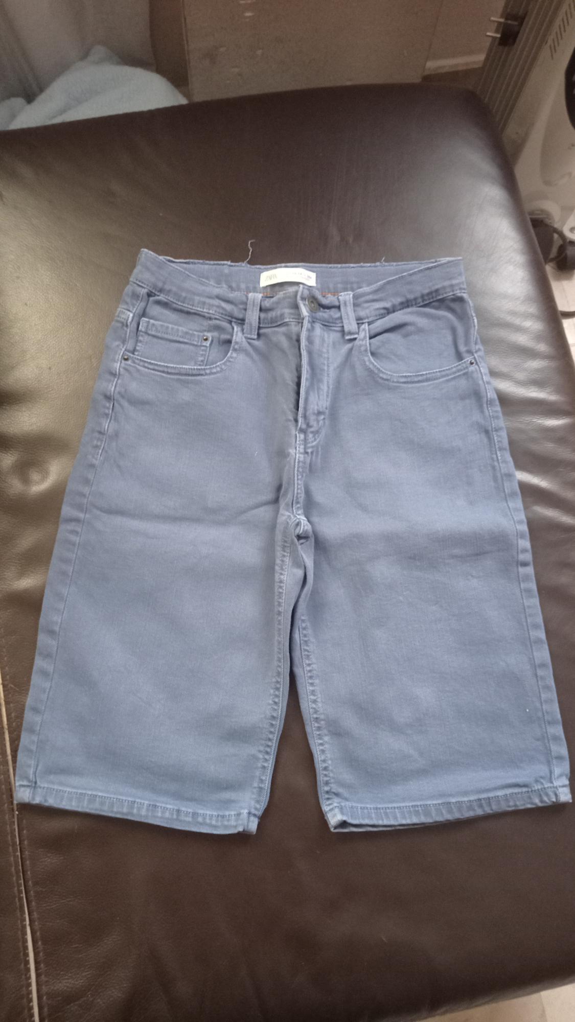 Front view of blue shorts with front pockets and belt loops.