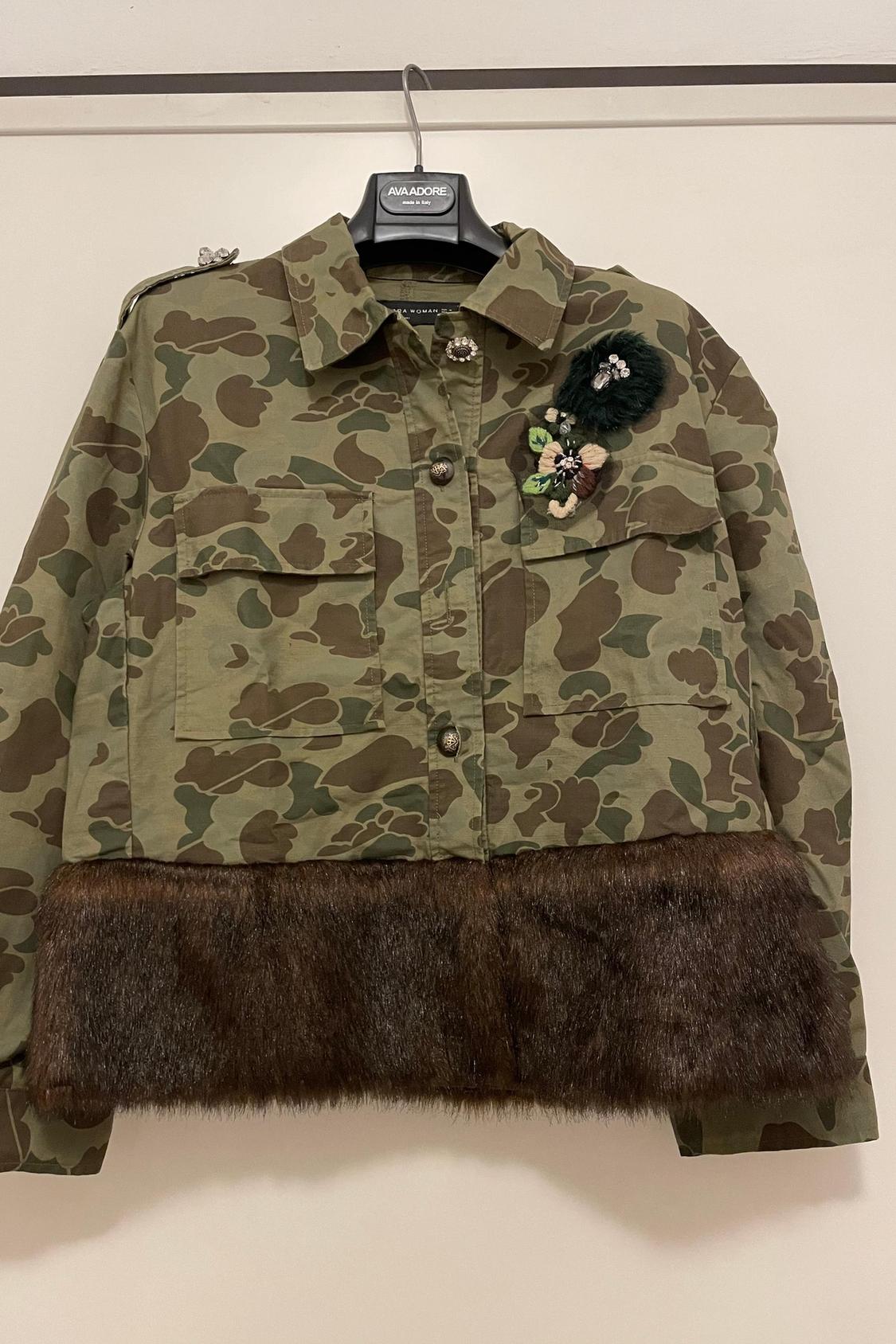 Front view of camouflage jacket with floral detail and front pockets, leather trim on the bottom hem.