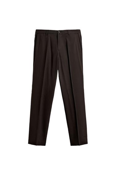 Front view of slim fit brown trousers with front and back double jetted pockets with button. Zip and button fastening.