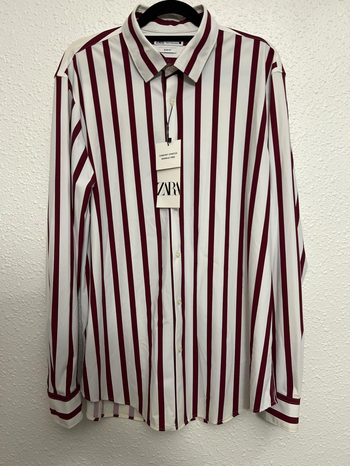 Red and white vertical striped shirt hanging on a hanger. Visible label with text: "COMFORT STRETCH FORMAL FREE" and "ZARA".