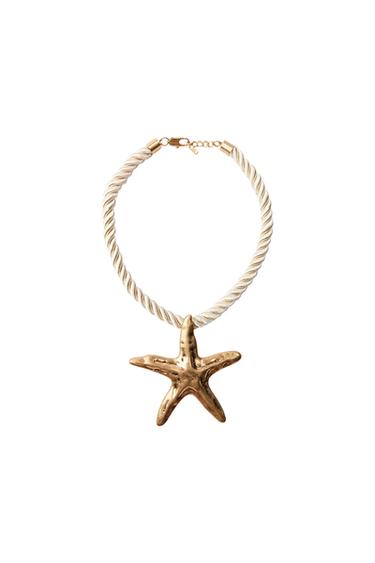 Necklace with white braided cord and gold starfish pendant on a white background.