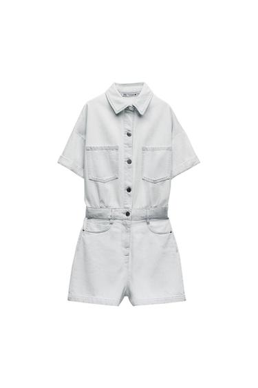 Light blue denim playsuit on a white background. Design with short sleeves, shirt collar, front buttons and pockets.