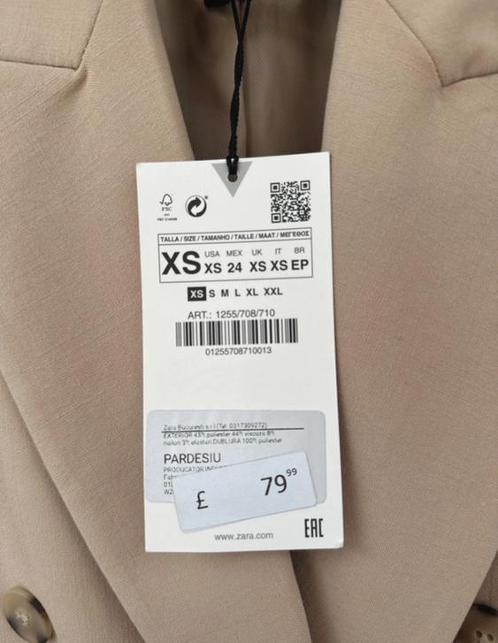 Beige jacket label with size XS information and price £79.99. Barcode and QR visible. Zara brand.