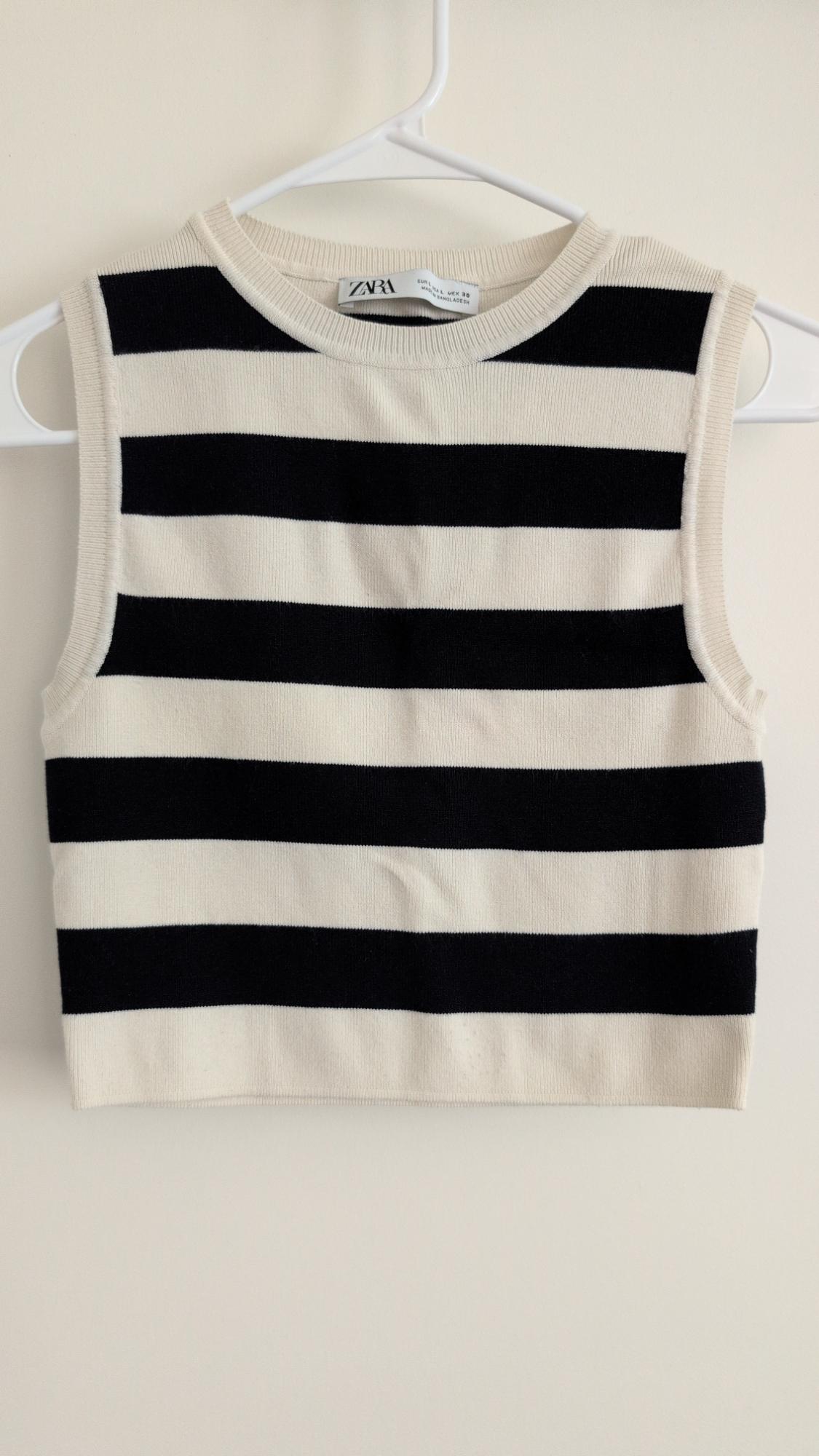 Black and white horizontal striped round neck sleeveless knit top on a hanger. Text: ZARA.