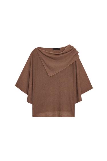 Front view of a sand-colored top with an asymmetrical neckline and wide sleeves.