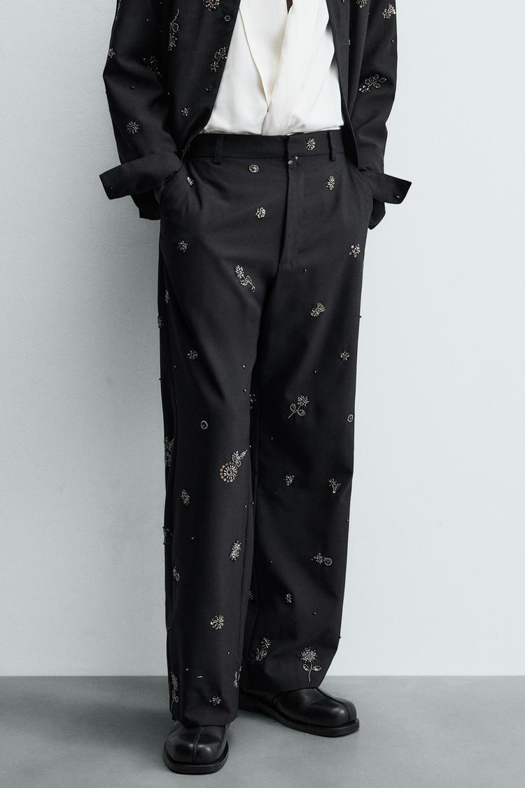 Ensemble pantalon bleu marine foncé à sequins, poches avant et arrière à rabat, fermeture zippée et crochet dissimulé.