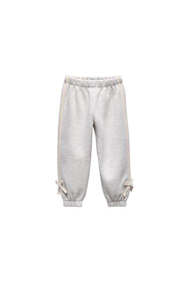 Front view of gray pants with ties at the ankles and elastic waistband.