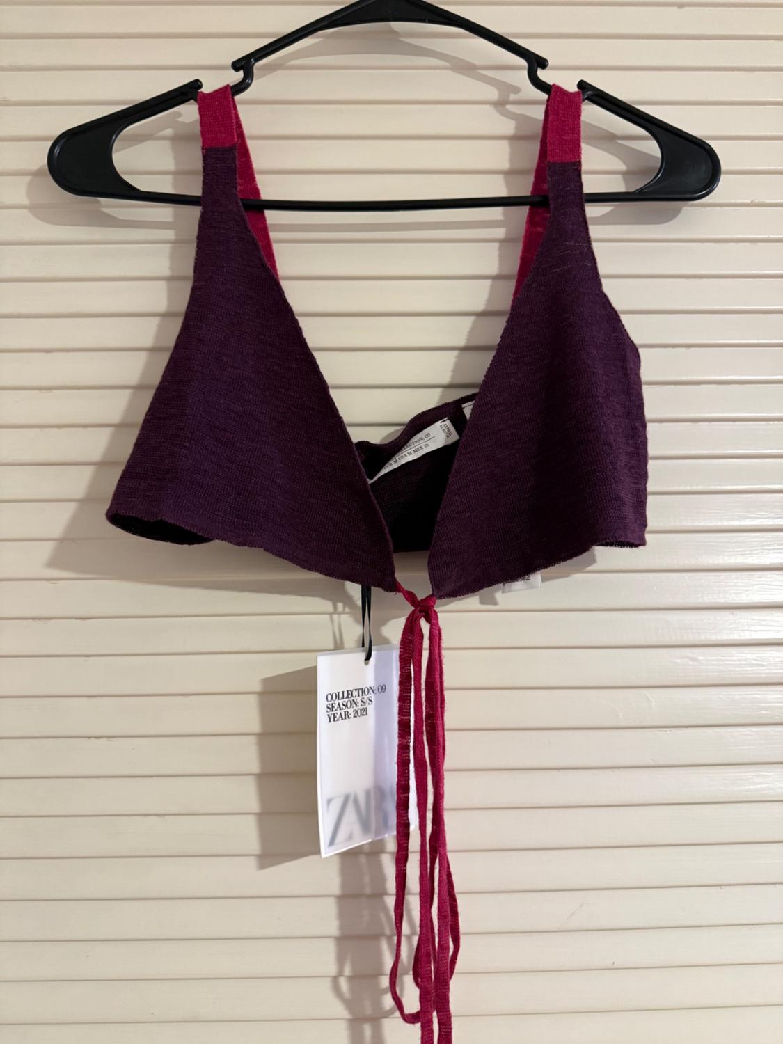 Purple crop top with red straps on a black hanger. Visible label: "COLLECTION 09 SEASON S/S YEAR 2023". White paneled background.