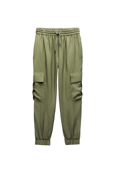 Olive green cargo trousers with an elasticated waistband, adjustable drawstring, side flap pockets, and elasticated cuffs on a white background.