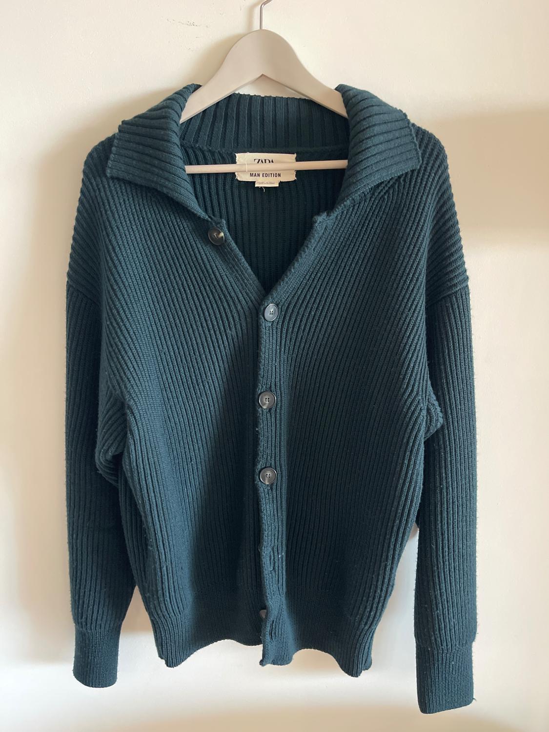 Front view of navy blue jumper with buttons and a wide collar.