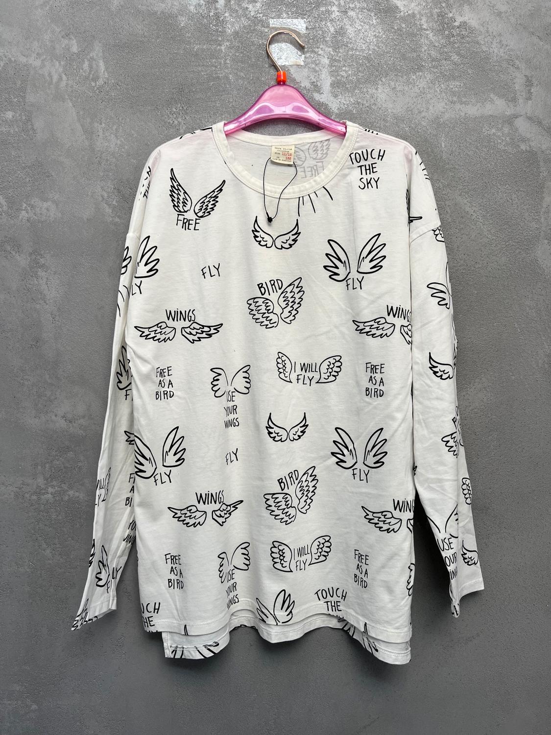 White long-sleeved T-shirt with wing designs and black text: "FREE", "FLY", "BIRD", "WINGS", "TOUCH THE SKY", "FREE AS A BIRD".