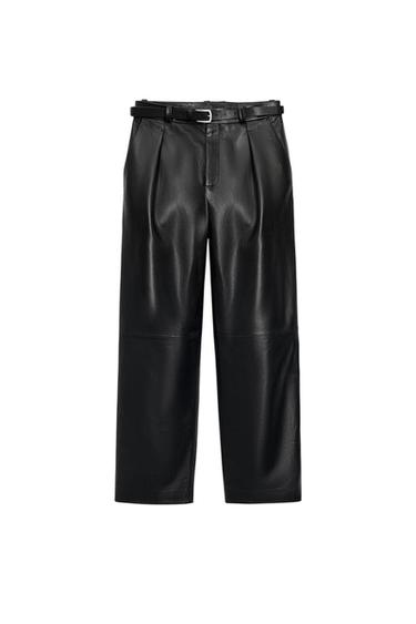Black wide-leg trousers with front pleats and matching slim belt with silver buckle, shown against a white background.