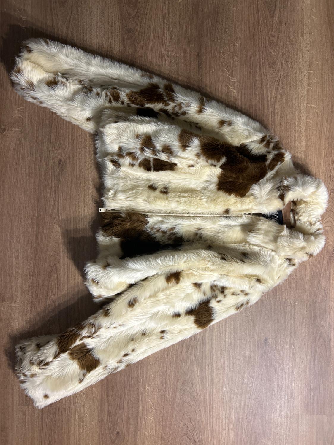 Faux leather jacket with brown and white spot print on wooden floor.
