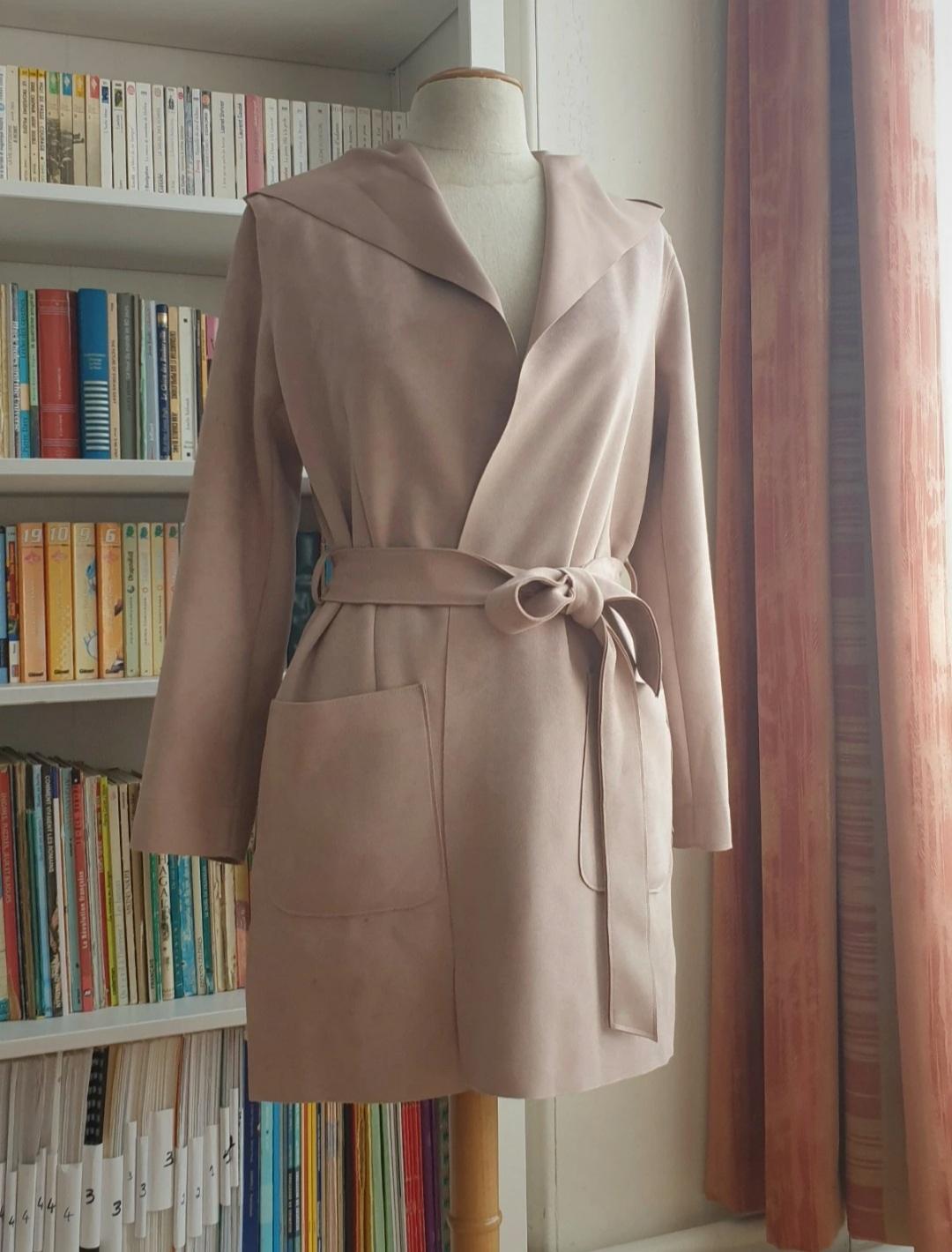 Front view of a beige coat with a belt and large front pockets.