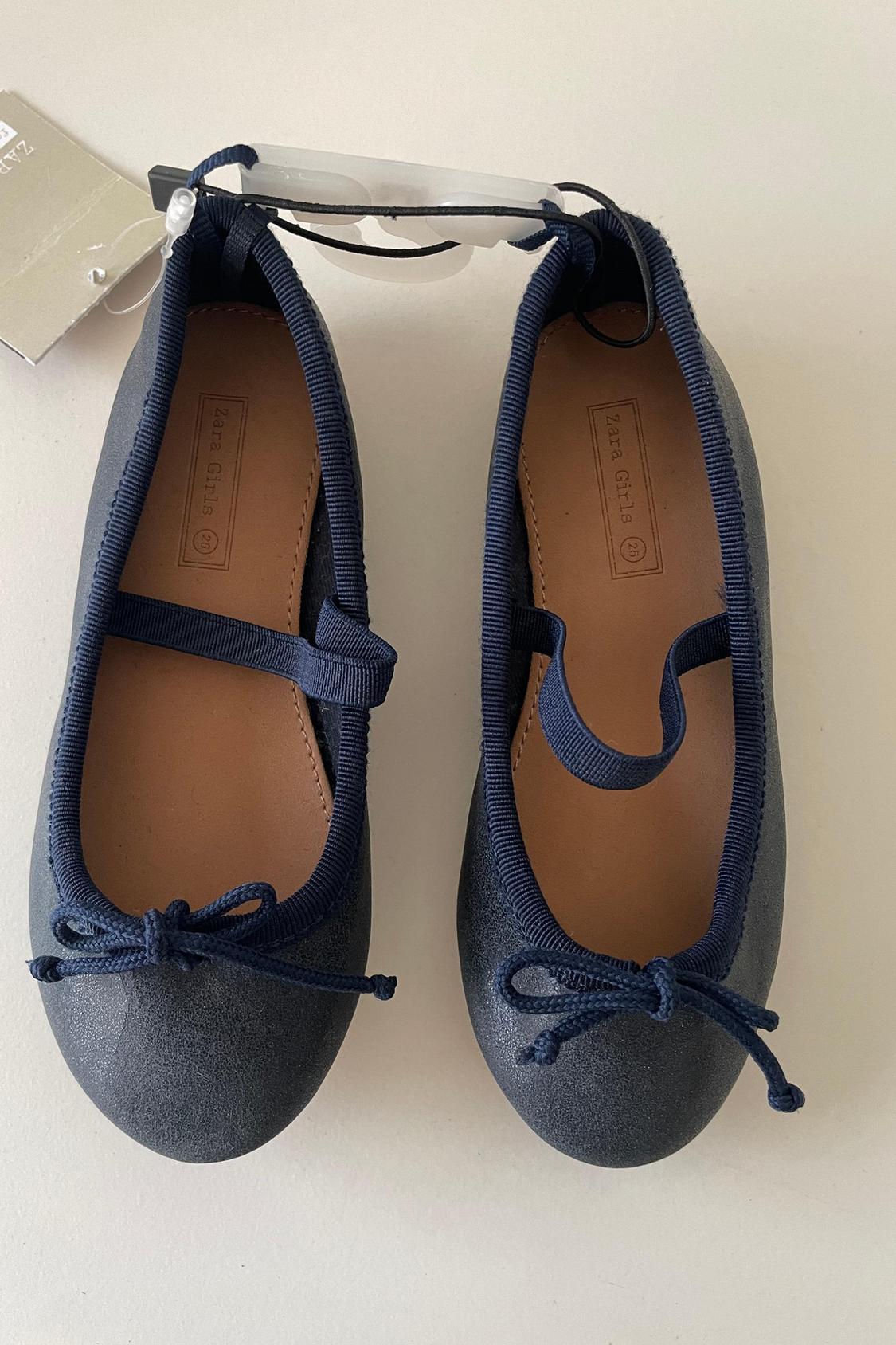 Front view of blue ballet flats with bow and visible label.