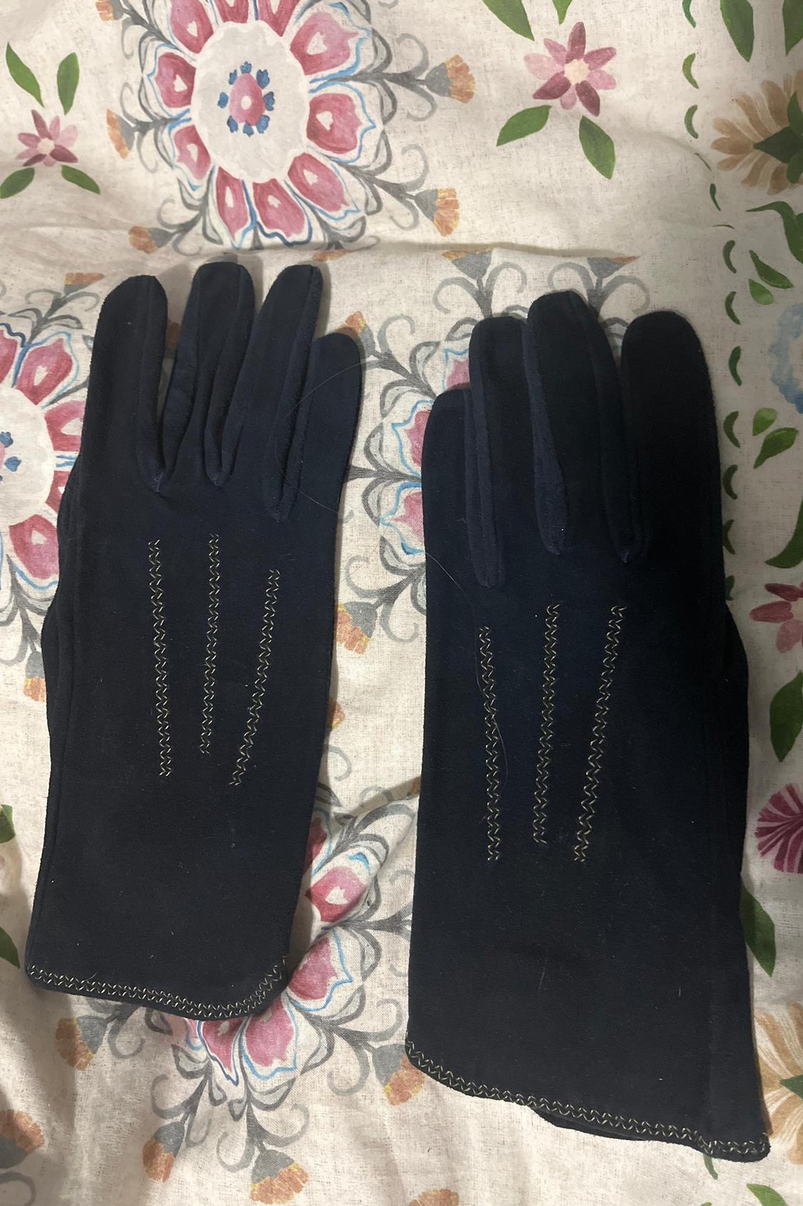 Front view of black gloves with decorative stitching on the back.