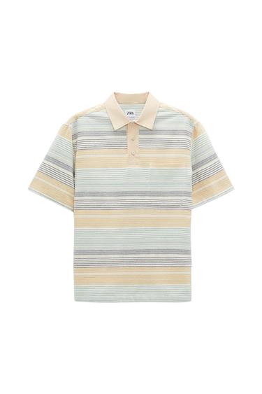 Polo shirt with horizontal stripes in beige, blue, and grey tones, with a beige collar and buttons. Visible label with text "ZARA".