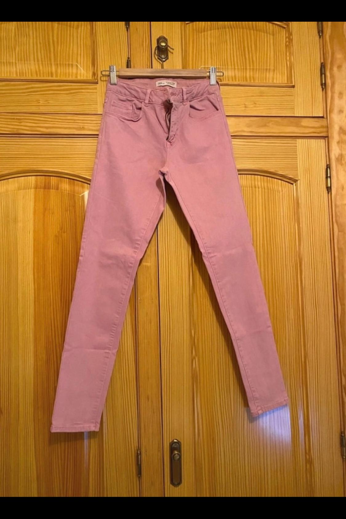 Front view of pink trousers with front pockets and button fastening.