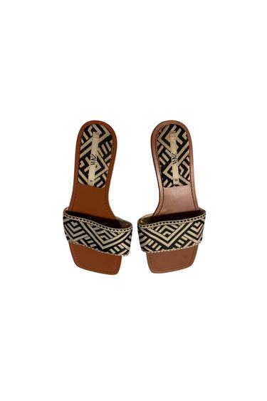 Flat sandals with a black and white geometric design, brown sole, and visible "ZARA" tag inside.