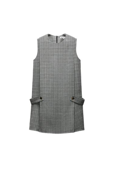 Grey check sleeveless mini dress, featuring a round neckline and side button-tab detailing on a white background.
