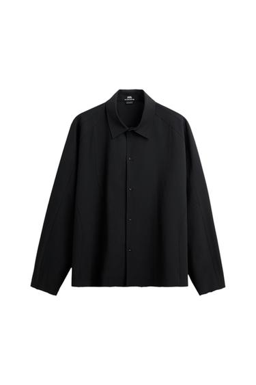 Black long-sleeved shirt with a collar, button-up front and decorative stitching against a white background. Interior label featuring ZARA text.