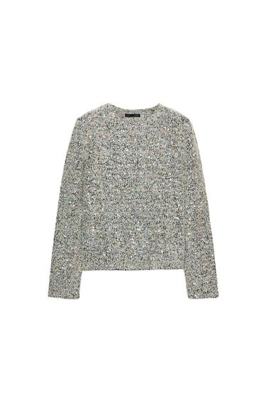 Front view of a light green sweatshirt with sequins, a round neck and long sleeves. Straight hem.