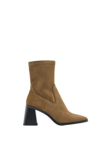 Brown high-heeled boot with a pointed toe and black block heel on a white background.