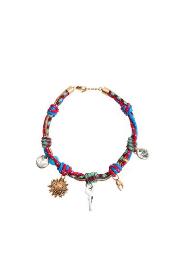 Multicoloured bracelet with key, flower and disc charms.