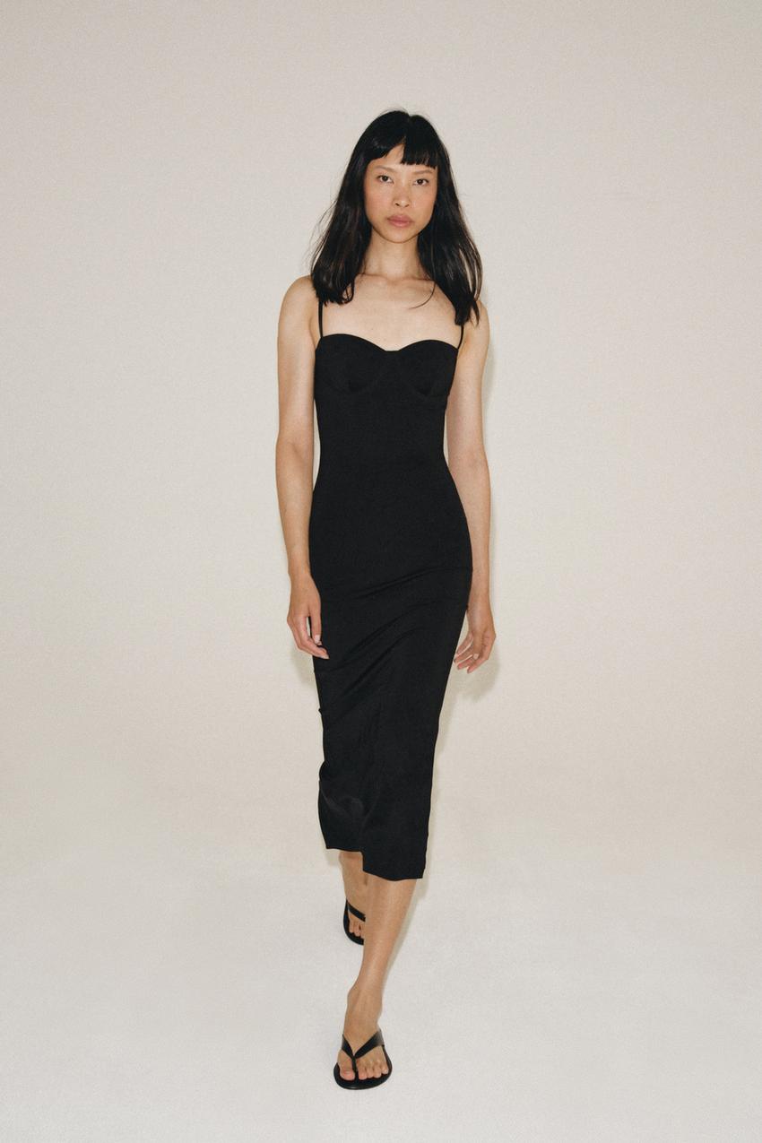 Black midi bodycon dress set with spaghetti straps and a sweetheart neckline, paired with black sandals.