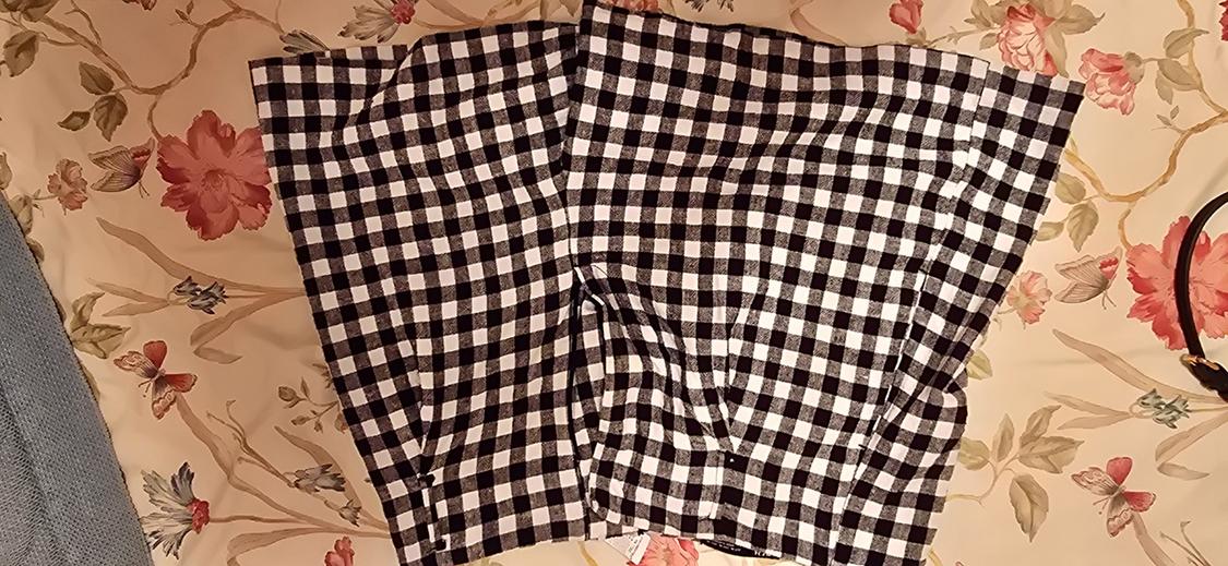 Black and white checked shorts set against a floral and butterfly print fabric background.